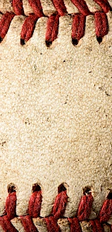 The image shows a close-up view of a baseball, highlighting its red stitching and textured leather surface.