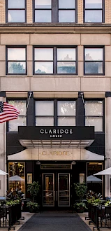 The image shows the exterior of Claridge House, featuring American and Chicago flags, with outdoor seating and umbrellas in front.