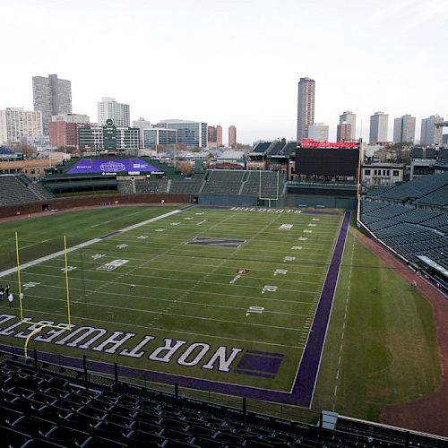 Wrigley Field Stadium with football field markings, empty seats, city skyline in background.