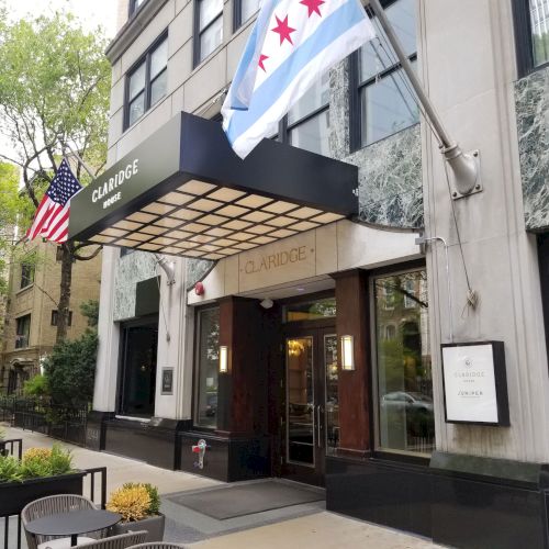 A cozy cafe or shop with a wooden front, outdoor seating, colorful awnings, and urban sidewalk, inviting street-level charm.