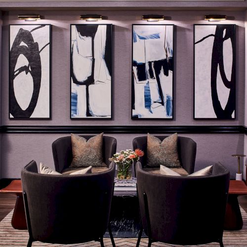 A living room with dark purple walls, a large TV, a beamed ceiling, two arched windows, and a group of people seated on a sofa watching TV.