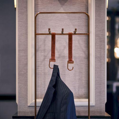 A street-side scene with a light fixture atop a small window sill and red cords hanging from a wooden post, with a dark jacket draped below.