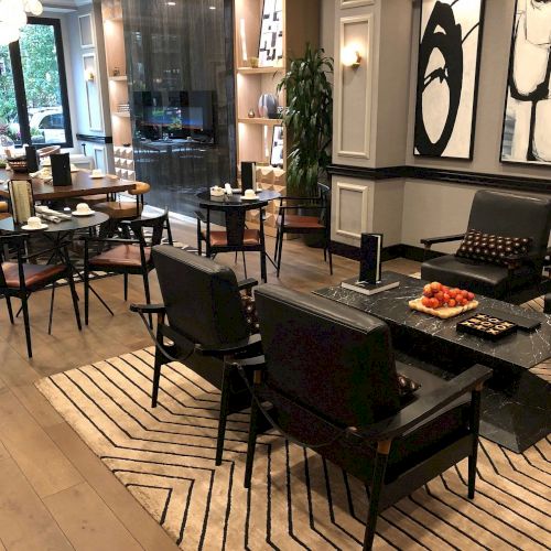 A modern music studio or showroom with a grand piano, chairs, and bright posters on the wall, plus wooden floors and warm lighting.