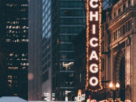 The image shows a street scene in Chicago with an illuminated sign reading 